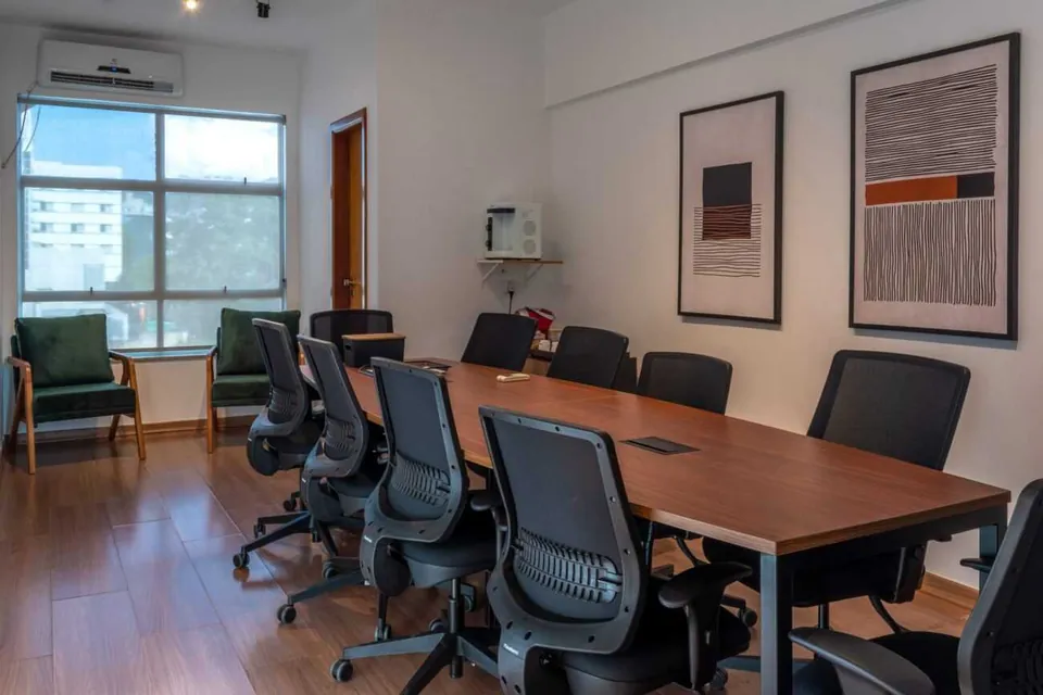 Sala de reunião do Desk Coworking em Belo Horizonte, com mesa central e cadeiras.